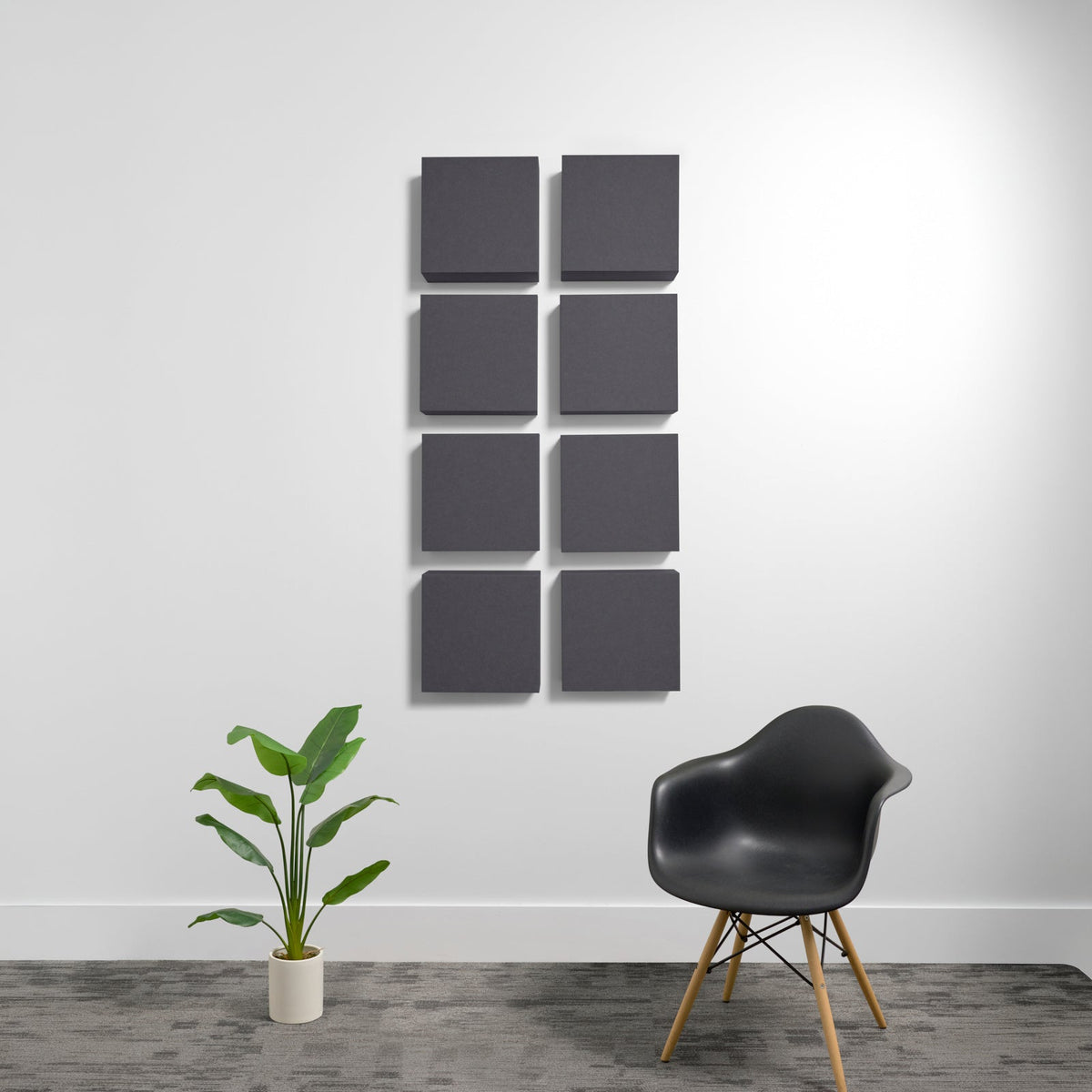 Eight dark gray square acoustic panels arranged in a 2x4 grid on a white wall.