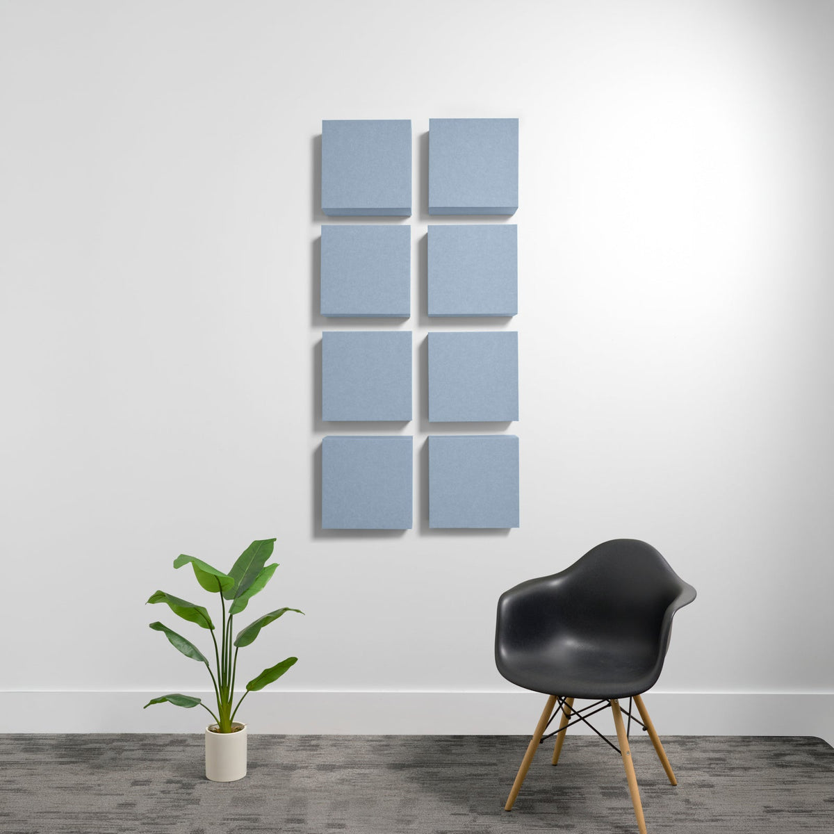 Eight blue-gray square acoustic panels arranged in a 2x4 grid on a white wall.
