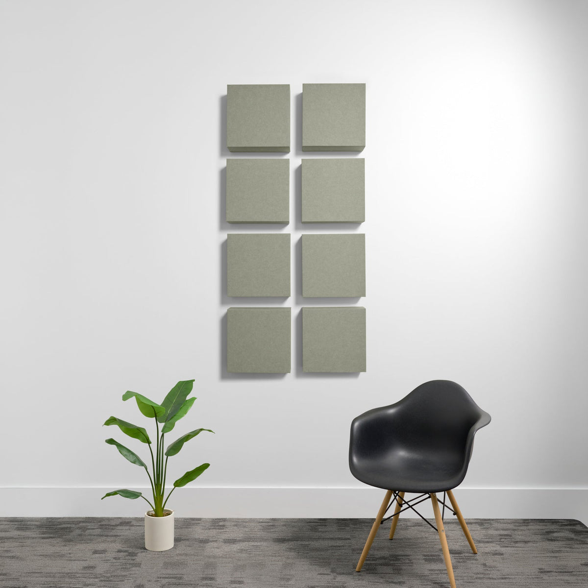 Eight square sage green acoustic panels mounted on white wall in 2x4 grid arrangement.