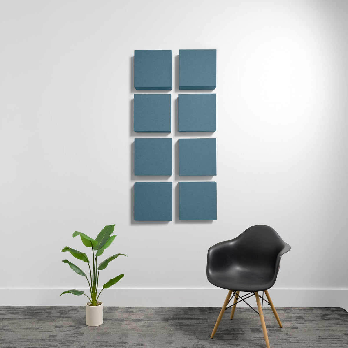 Eight teal square acoustic panels arranged in a 2x4 grid on a white wall.