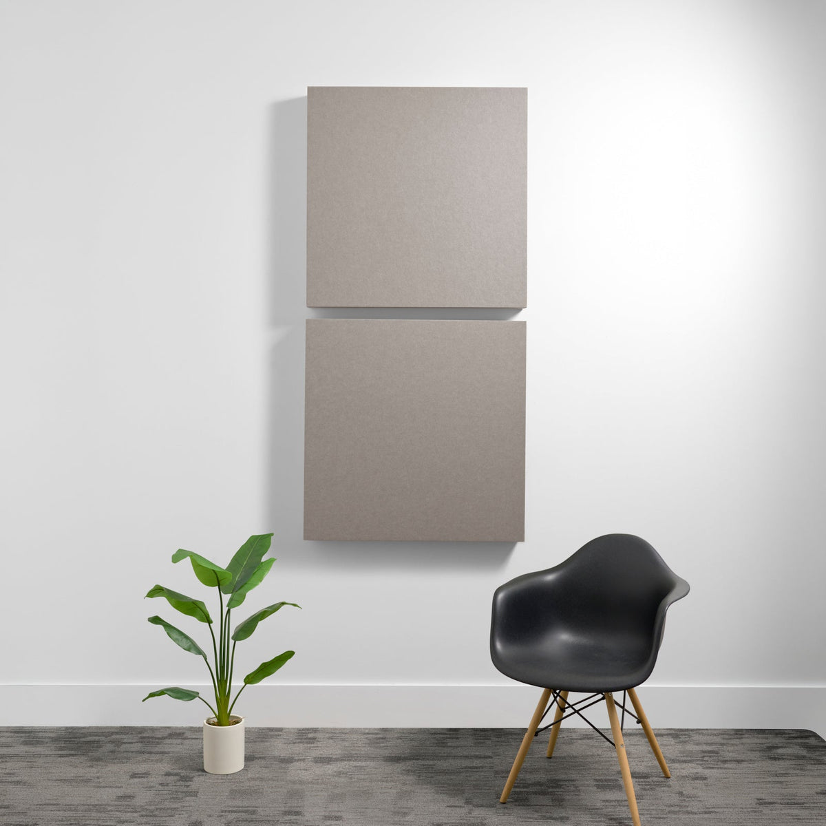 Two gray square acoustic panels mounted vertically on a white wall.