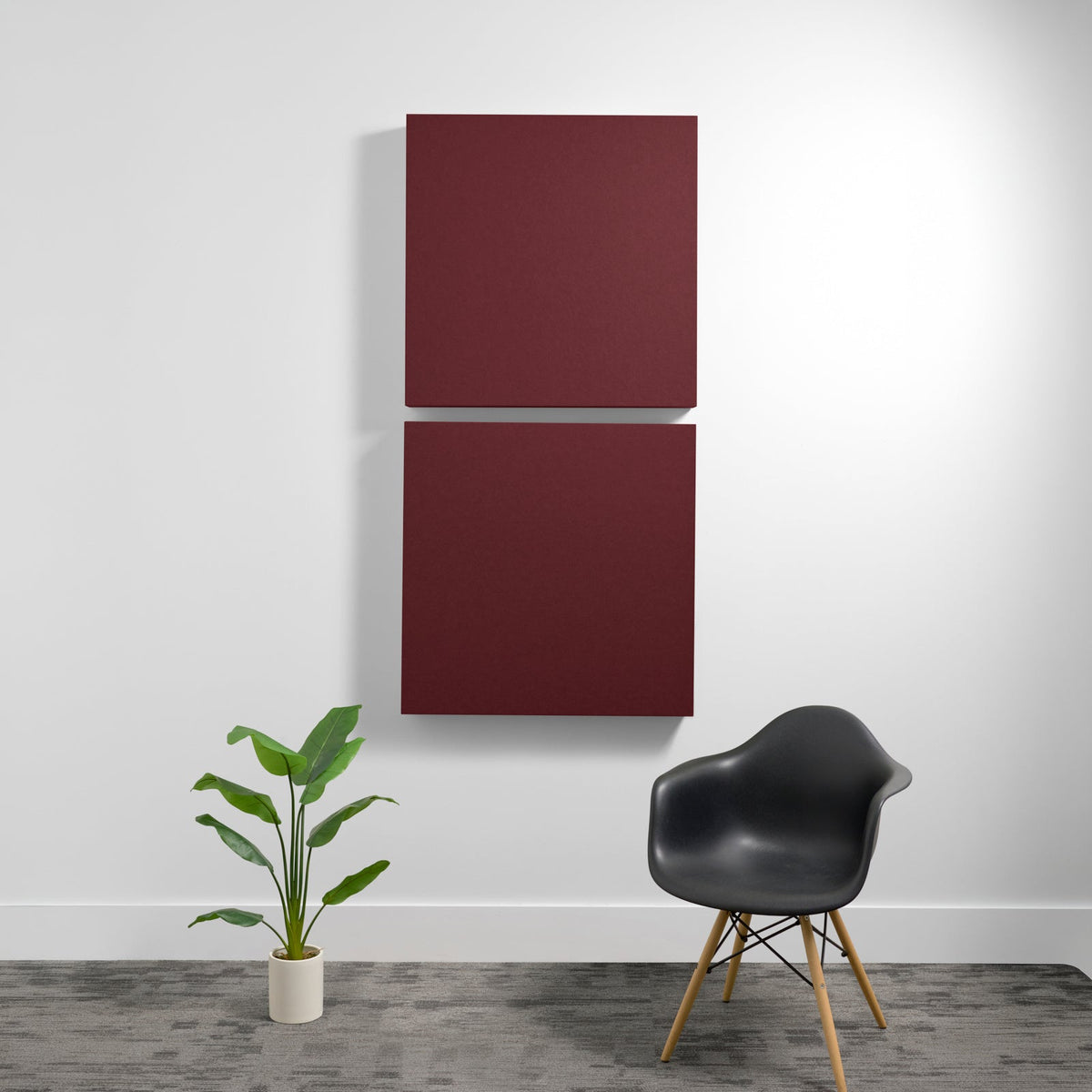 Two burgundy square acoustic panels mounted vertically on a white wall.