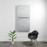 Two light gray textured acoustic panels stacked vertically on a white wall.