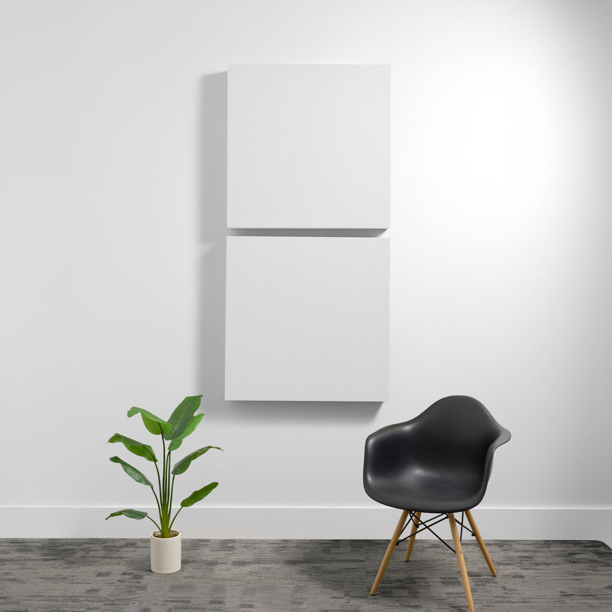 Two white square acoustic panels mounted vertically on a wall with a gap between them.