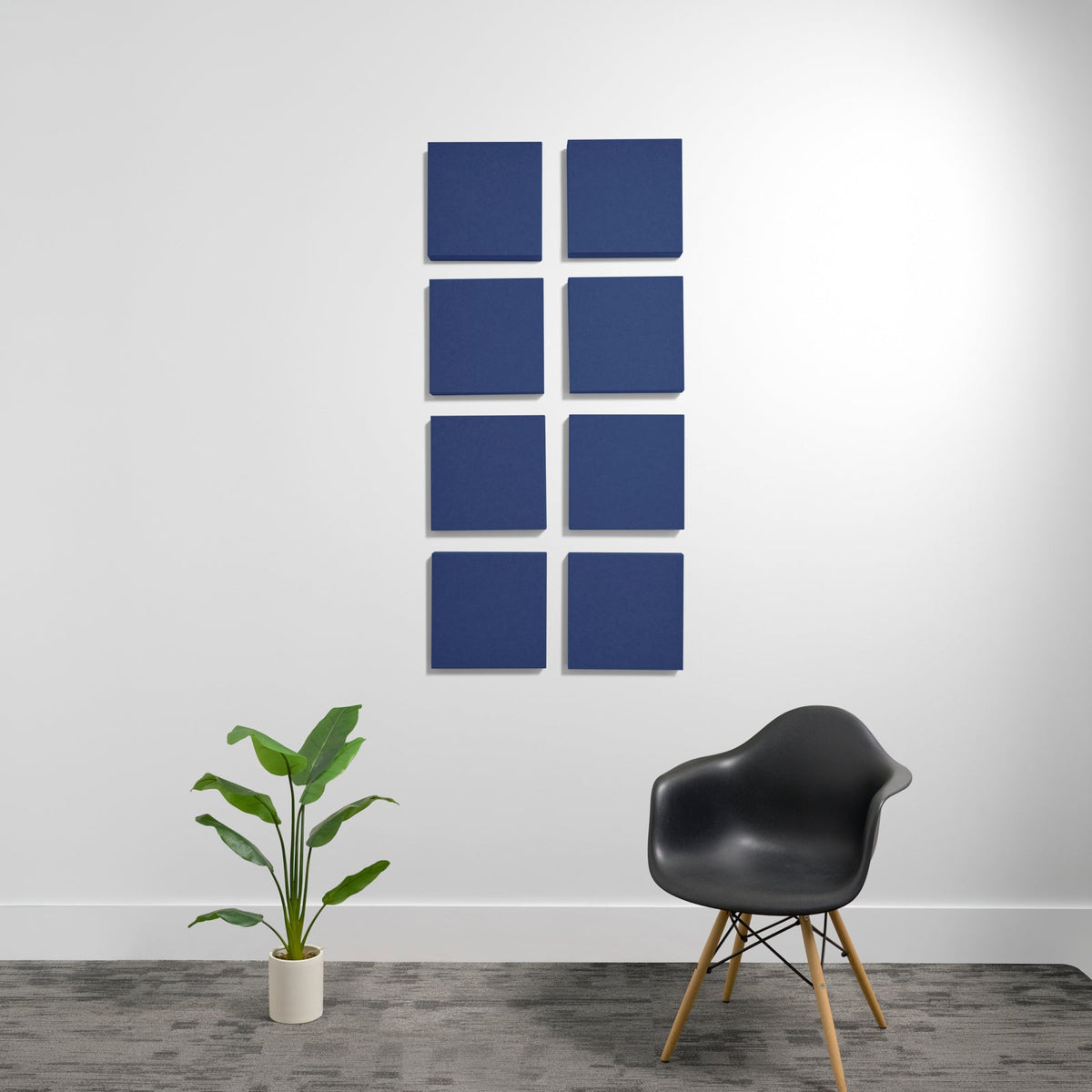 Eight dark blue square acoustic panels arranged in a 2x4 grid on a white wall.