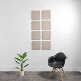 Eight square beige acoustic panels arranged in a 2x4 grid on a white wall.