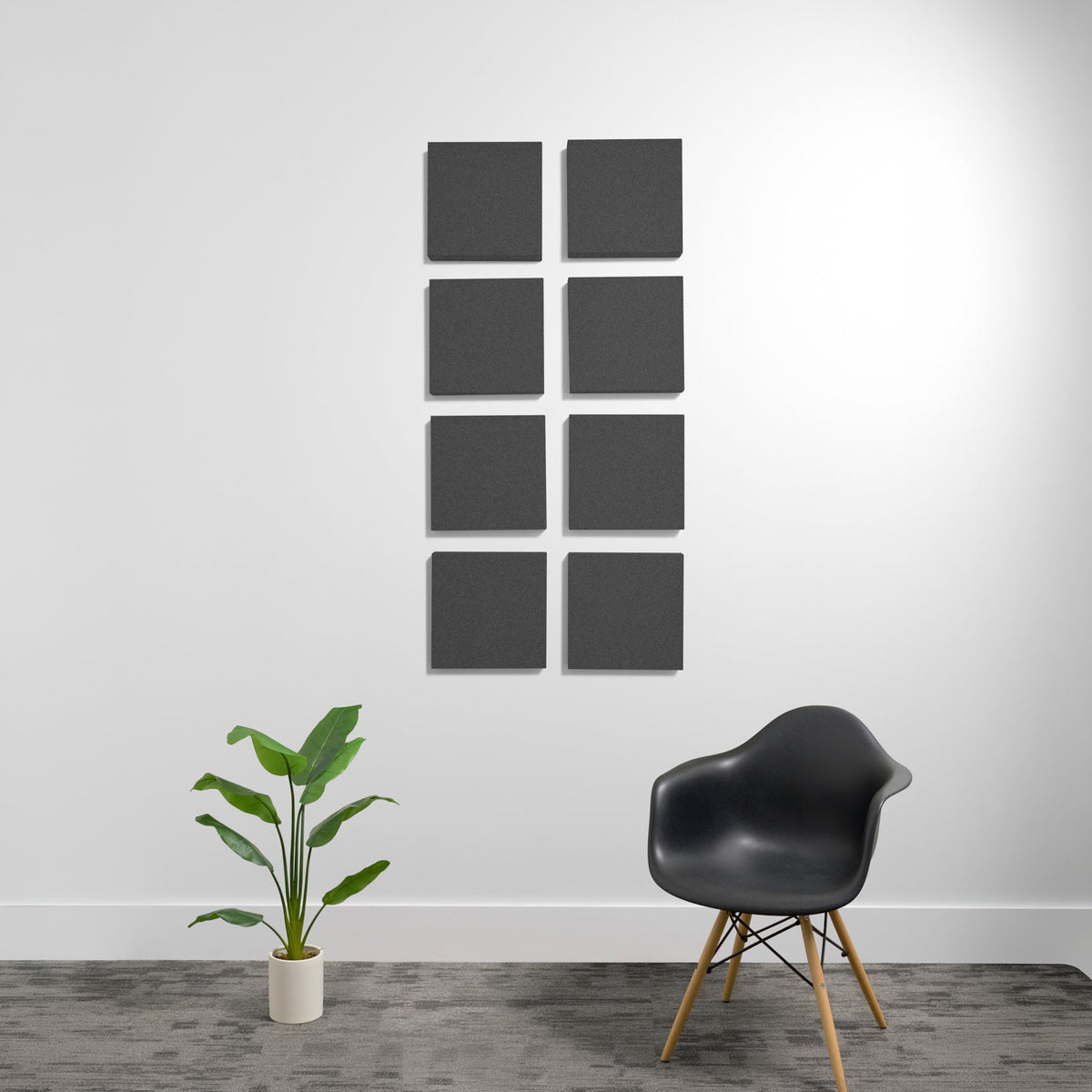 Eight dark gray square acoustic panels arranged in a 2x4 grid on a white wall.