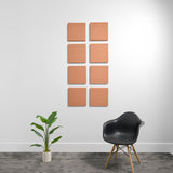 Eight terracotta-colored square acoustic panels arranged in a 2x4 grid on white wall.