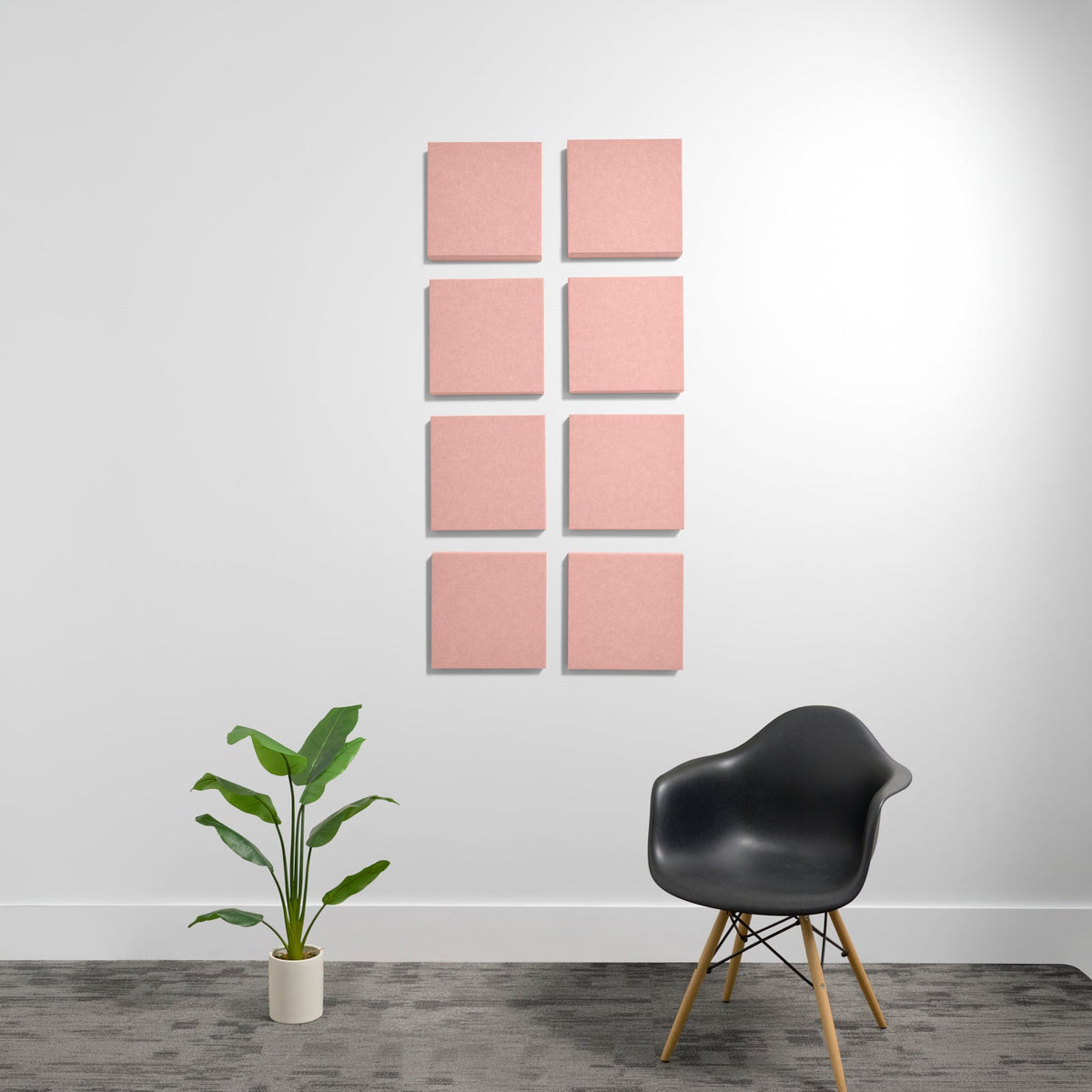 Eight pink square acoustic panels arranged in a 2x4 grid on a white wall.