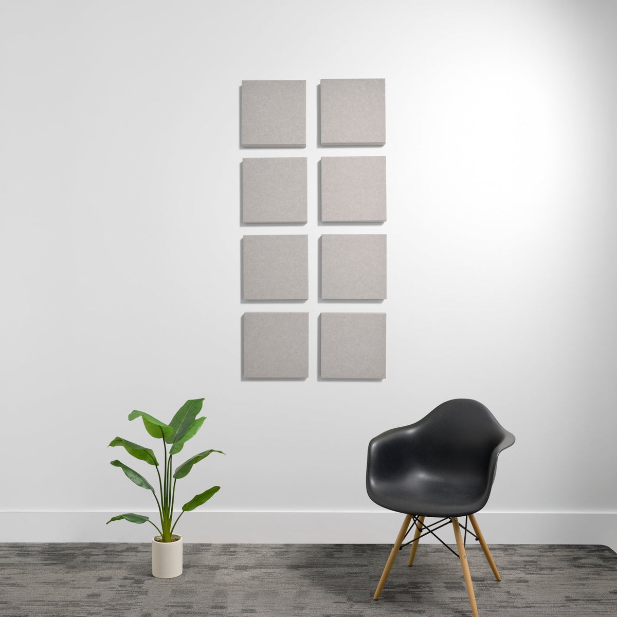 Eight beige square acoustic foam panels arranged in a 2x4 grid on a white wall.