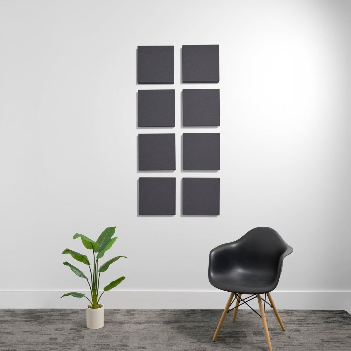 Eight charcoal gray square acoustic panels mounted on white wall in 2x4 grid arrangement.