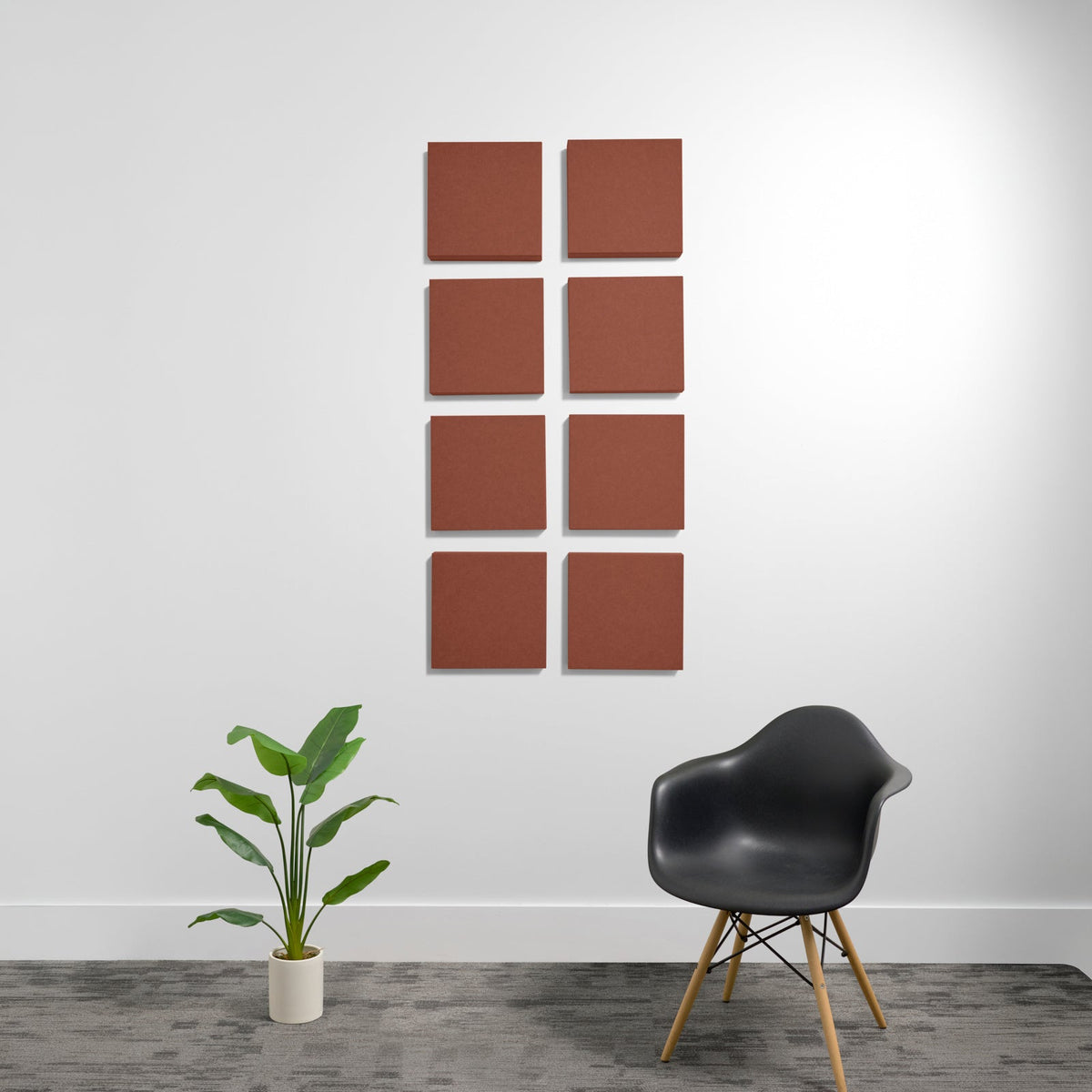 Eight terracotta-colored square acoustic panels with beveled edges mounted on a white wall.