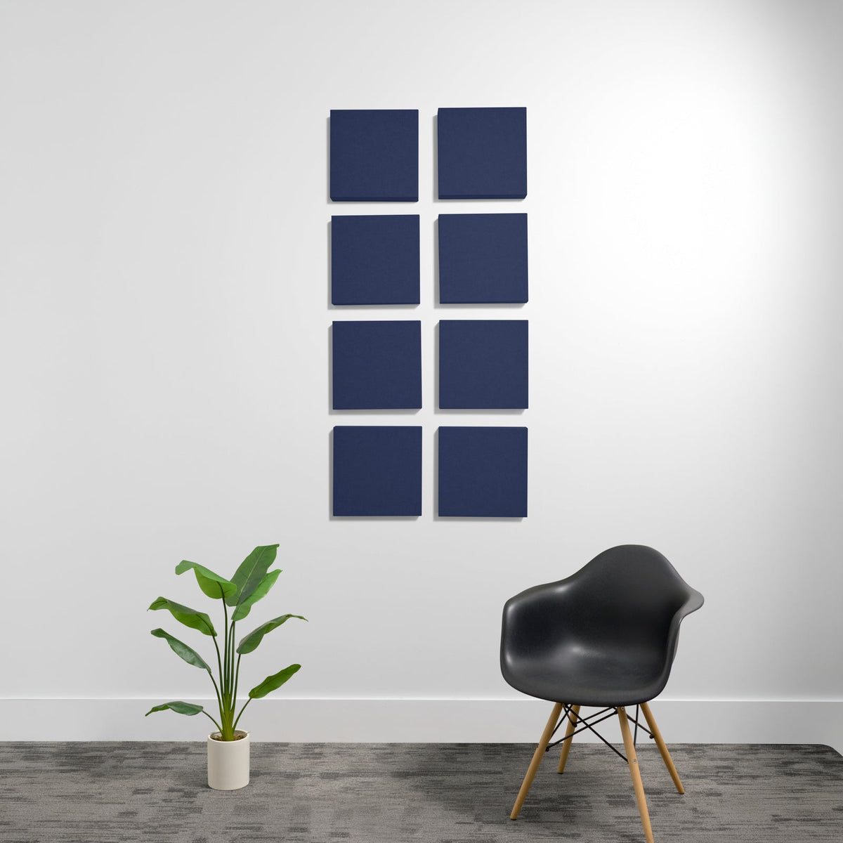 Eight dark blue square acoustic panels arranged in a 2x4 grid on a white wall.