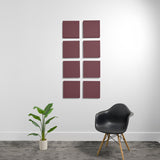 Eight burgundy square acoustic panels mounted on white wall in 2x4 grid arrangement.