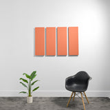 Four rectangular orange acoustic panels mounted on wall above chair and plant.