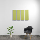 Four lime-green rectangular acoustic panels mounted on white wall above black chair and potted plant.