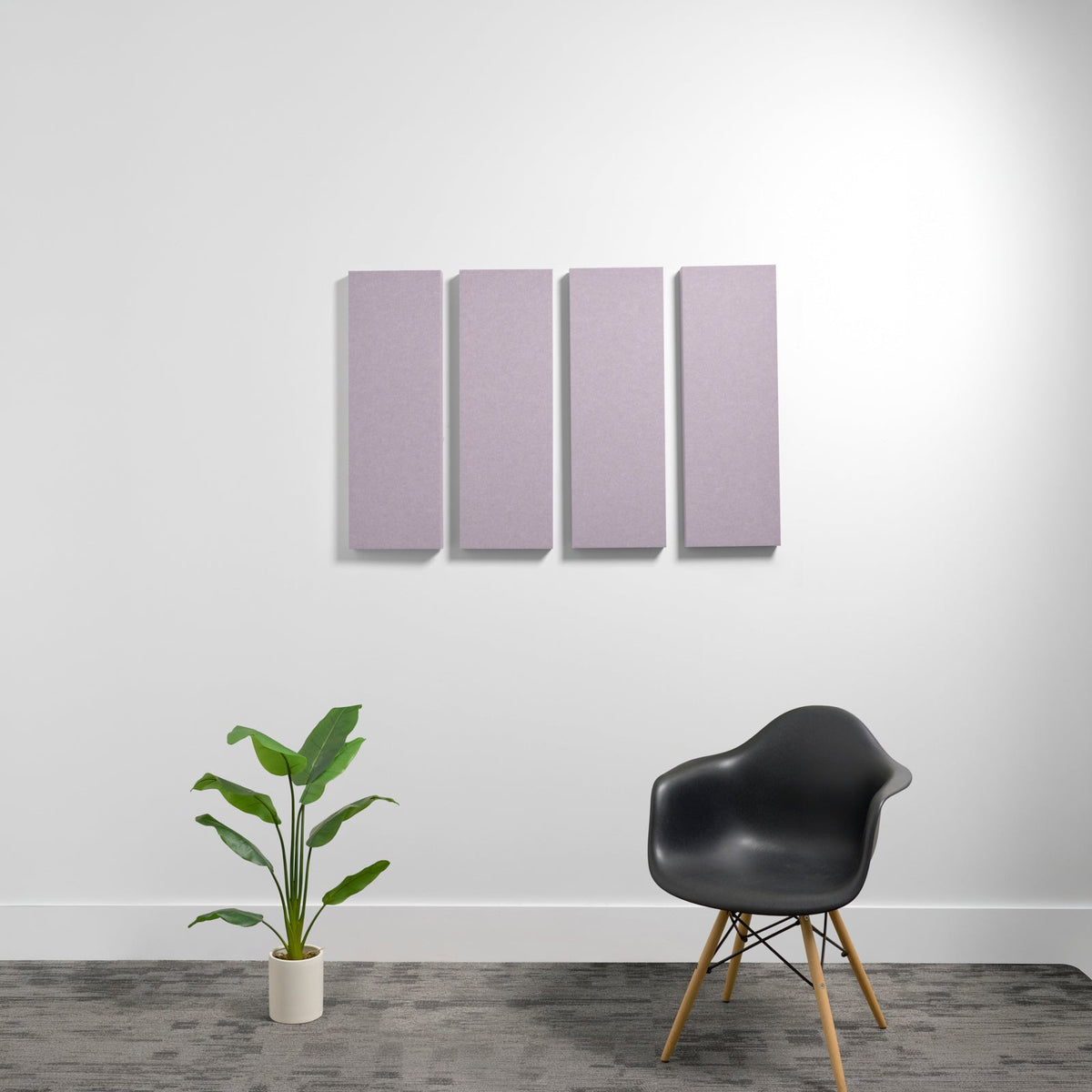 Four rectangular lavender acoustic panels mounted on a white wall above a black chair and potted plant.