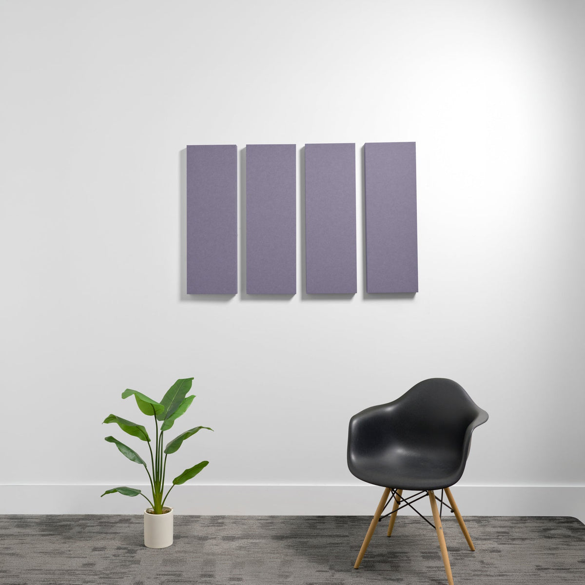 Four purple rectangular 3D acoustic panels mounted on white wall above a black chair and potted plant.