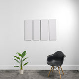 Four white rectangular acoustic panels mounted on wall above black chair and potted plant.