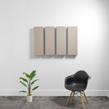 Four beige rectangular acoustic panels mounted on white wall above black chair and potted plant.