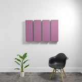 Four rectangular mauve acoustic panels mounted on a white wall above a black chair and potted plant.