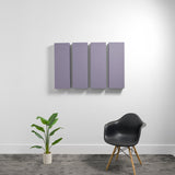 Four purple rectangular acoustic panels mounted on white wall above black chair and potted plant.