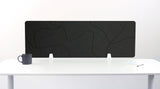 Black desk divider with curved topographic pattern design mounted on white desk with support feet.