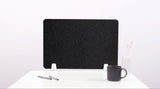 Black fabric desk divider with curved topographic pattern and white support feet on desk.