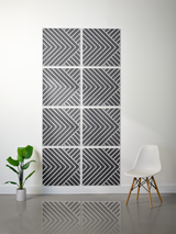 Eight gray tiles with layered engraved diagonal stripe and chevron pattern arranged in a 2x4 grid on a wall.