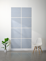 Eight blue-gray tiles with engraved chevron and diagonal line patterns arranged in a grid formation on a wall.