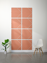 Eight square tiles with orange and gray chevron and diagonal line engraved patterns arranged in a 4x2 grid on a wall.