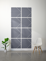 Eight square tiles with engraved diagonal stripe and chevron patterns in navy and white, arranged in a 2x4 grid on a wall.