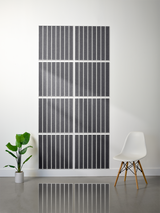 Eight dark gray tiles with vertical parallel line engravings arranged in a 2x4 grid on a white wall.
