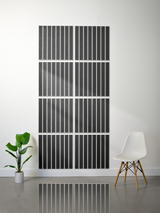 Set of eight black tiles with parallel vertical line engravings arranged in a 2x4 grid on a wall.