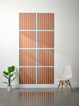 Eight terracotta tiles with white vertical engraved lines arranged in a 2x4 grid on a wall.