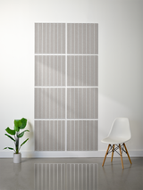 Eight gray tiles with vertical parallel line engravings arranged in a 2x4 grid on a wall.
