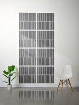 Eight gray tiles with white engraved vertical line pattern arranged in offset rows on wall.
