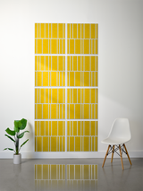 Eight yellow tiles with white engraved vertical lines arranged in an offset pattern on a wall.
