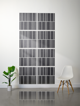Eight dark gray tiles with white engraved vertical line pattern arranged in offset rows on wall.