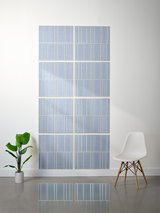 Eight blue-grey tiles with white engraved vertical line pattern in offset arrangement on wall.