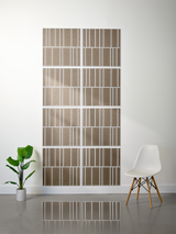Eight taupe tiles with white engraved vertical stripe pattern arranged in offset rows on wall.