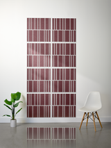 Eight burgundy tiles with white engraved vertical stripe patterns arranged in offset rows on a wall.