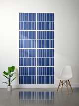 Eight blue tiles with white engraved vertical stripe pattern arranged in offset configuration on wall.