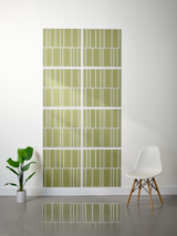 Eight olive green tiles with white engraved vertical stripe pattern arranged in offset rows on wall.