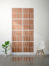 Eight terracotta tiles with white engraved linear pattern arranged in offset layout on wall.