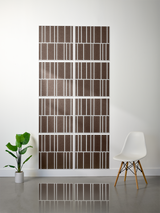 Eight brown tiles with white vertical engraved line patterns arranged in offset rows on a wall.