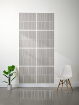 Eight gray tiles with offset white engraved linear patterns arranged in a 2x4 grid on white wall.