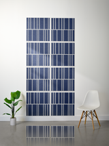 Eight navy blue tiles with white engraved vertical line patterns arranged in offset formation on a wall.