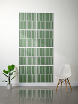 Eight green tiles with white engraved vertical line pattern arranged in offset rows on wall.