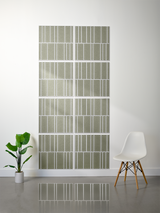 Eight sage green rectangular tiles with white engraved vertical lines in offset pattern arrangement on wall.